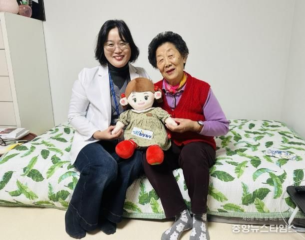 화성시동탄보건소 관계자와 독거 어르신이 AI 돌봄로봇 ‘효돌이’를 함께 들고 환하게 웃고 있다.(화성특례시 제공)