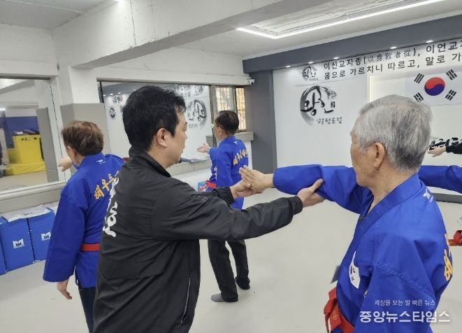 해우름 태권단원 어르신이 태권도 사범의 지도를 받고 있다.